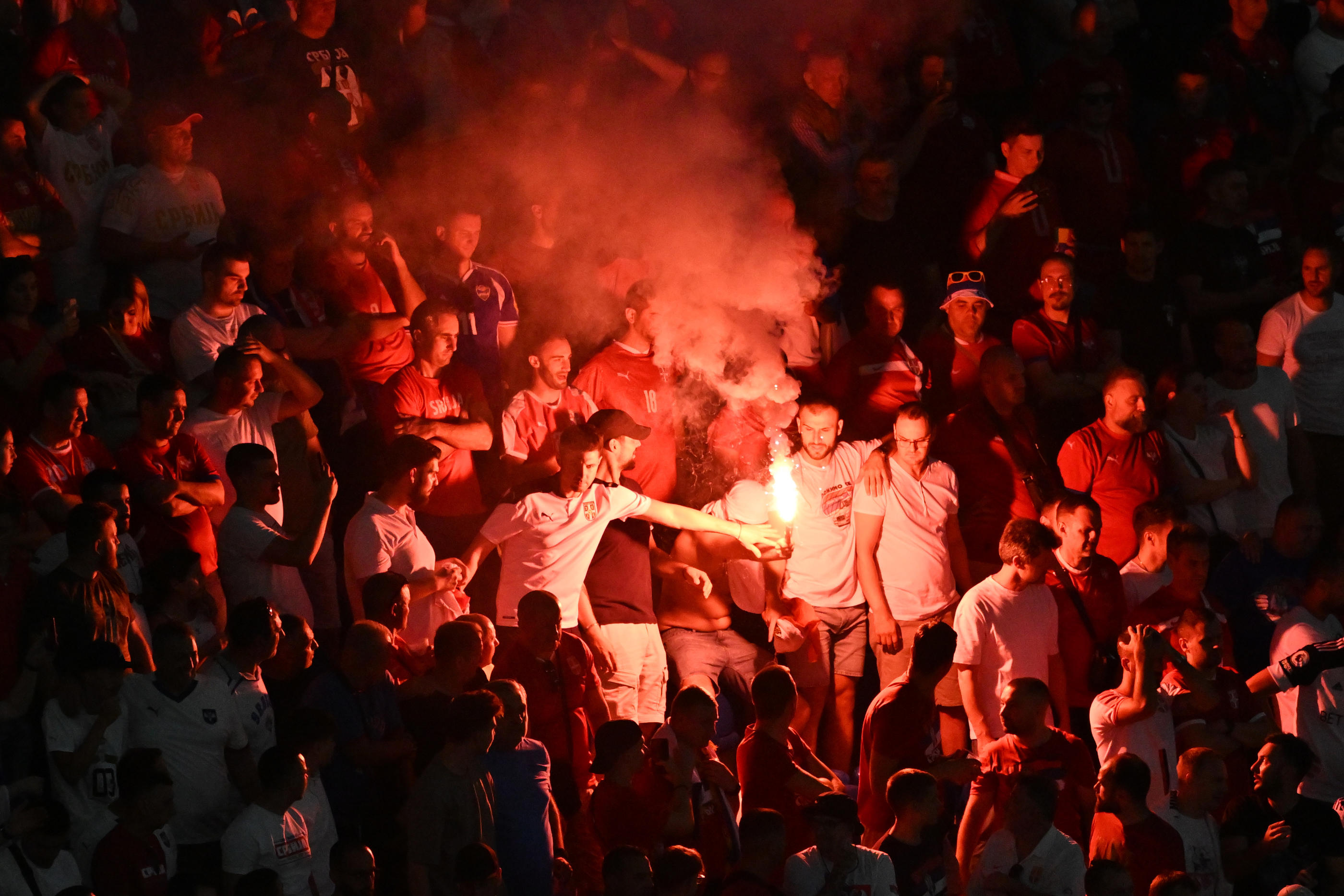Des engins pyrotechniques en tribunes lors du match Danemark - Serbie en phase de groupes. Peter Kneffel/dpa