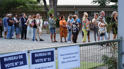 Des personnes font la queue devant un bureau de vote dans le quartier de Magenta avant de voter lors du premier tour des élections législatives françaises à Nouméa, dans la première circonscription du territoire français du Pacifique de Nouvelle-Calédonie, le 30 juin 2024.