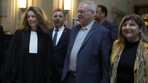 Obeida Dabbagh, frère de Mazen Dabbagh, victime franco-syrienne du régime de Damas, et sa femme Hanane (à droite) à leur arrivée à la salle d'audience à Paris avec leur avocate Clemence Bectarte (à gauche) et l'avocat syrien Mazen Darwish, le 21 mai 2024.