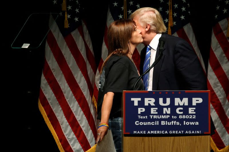 FILE PHOTO: Root is greeted with a kiss from Trump as she takes the stage to speak to a rally with Trump supporters in Council Bluffs, Iowa, U.S.