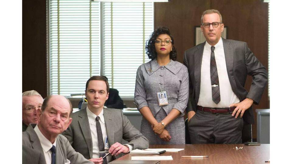 Kevin Costner (far right) in Hidden Figures alongside Taraji P Henson (middle) and Jim Parsons (left). Jim is sat at a large desk and Taraji and Kevin are standing.