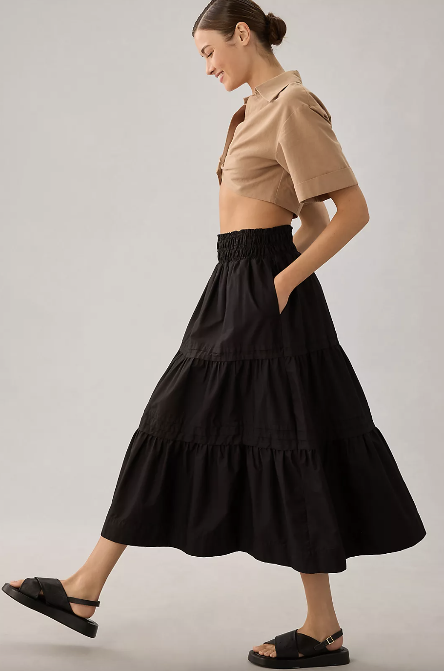 model wearing beige crop top, black shoes and The Somerset Maxi Skirt in black (photo via Anthropologie)