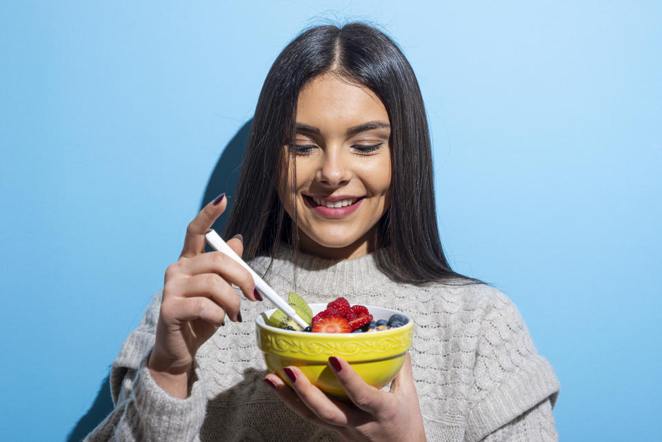Young woman eating muesli breakfast on blue background.Studio Shot. Sharp cautioned that while cutting out sugar can have benefits, long-term restrictive diets may lead to binge eating. (Image via Getty)