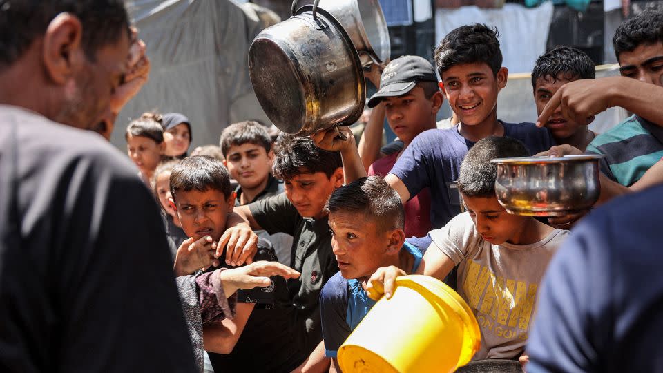 Children line up for food aid in Jabalya refugee camp, the northern Gaza, on June 13. Relief agencies have accused Israeli authorities of blocking humanitarian access to the area, amid dire food shortages. - Omar Al-Qattaa/AFP/Getty Images