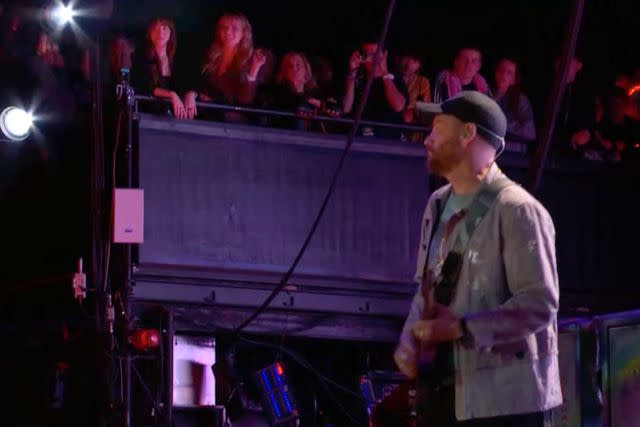 <p>BBC</p> Dakota Johnson watches Chris Martin's set with Coldplay at the Glastonbury Festival.