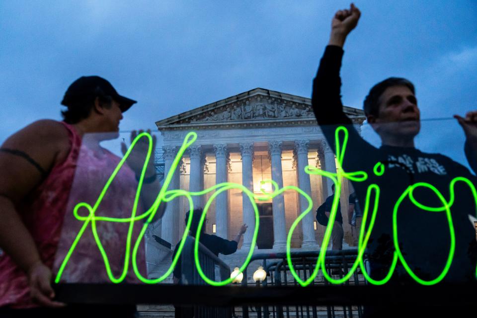 Protesters mark the first anniversary of the Supreme Court's decision overturning Roe v. Wade by displaying a neon sign in support of abortion access on June 23, 2023.