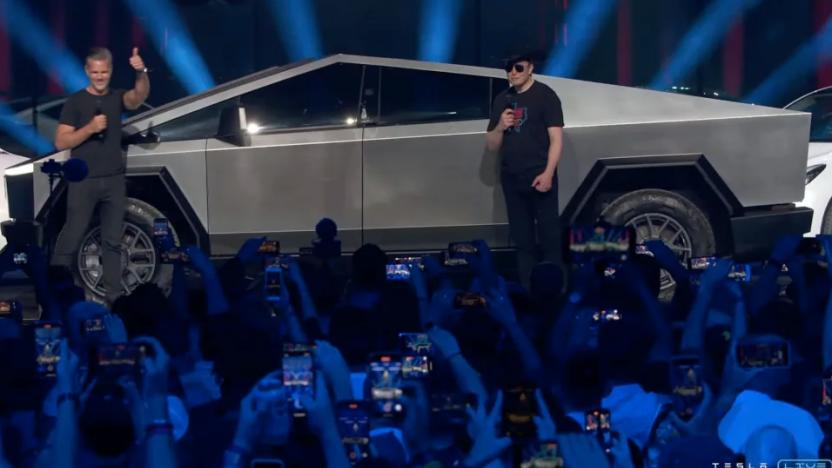 Elon Musk standing next to a Cybertruck.