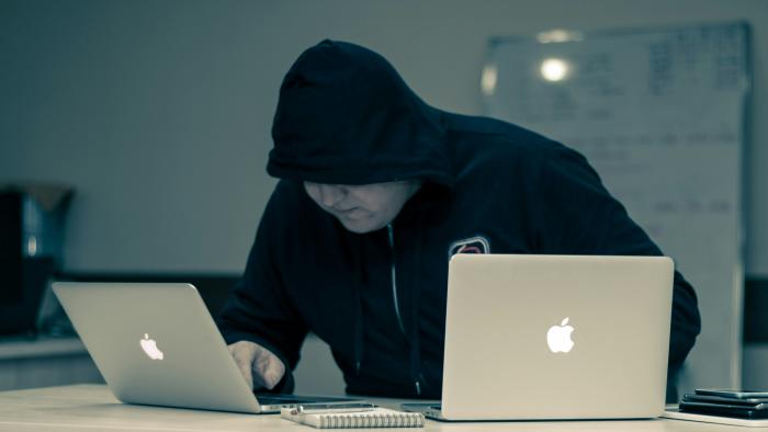 A hooded hacker doing hooded hacker things.