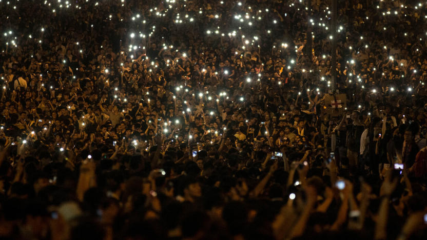 Nighttime shot of countless protestors holding up their phones’ flashlights.