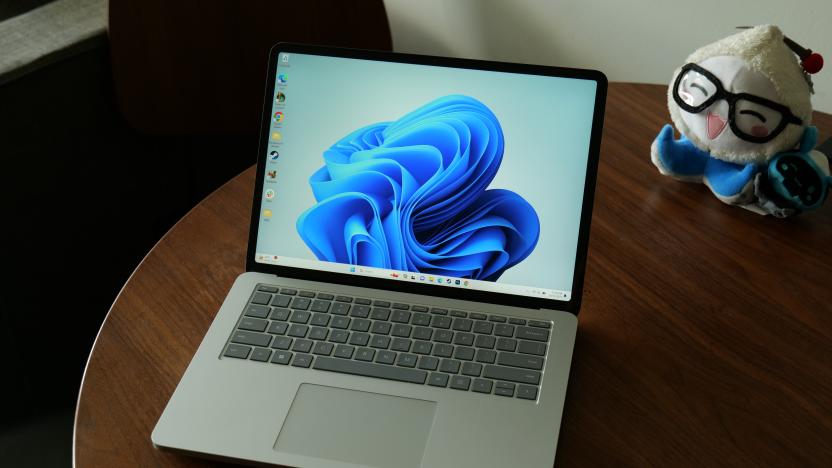 Product review photo of the Microsoft Surface Laptop 2, sitting on a desk next to a stuffed toy.