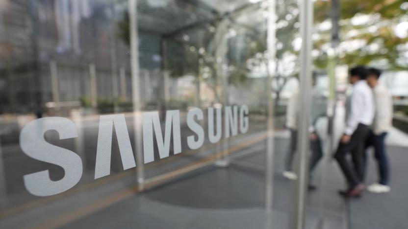 Employees walk past the logo of the Samsung Electronics Co. at its office in Seoul, South Korea,Tuesday, Oct. 31, 2023. Samsung Electronics on Tuesday reported its highest quarterly profit for the year and saw narrowed losses from its computer chip business amid a slow recovery in global demand.(AP Photo/Ahn Young-joon)