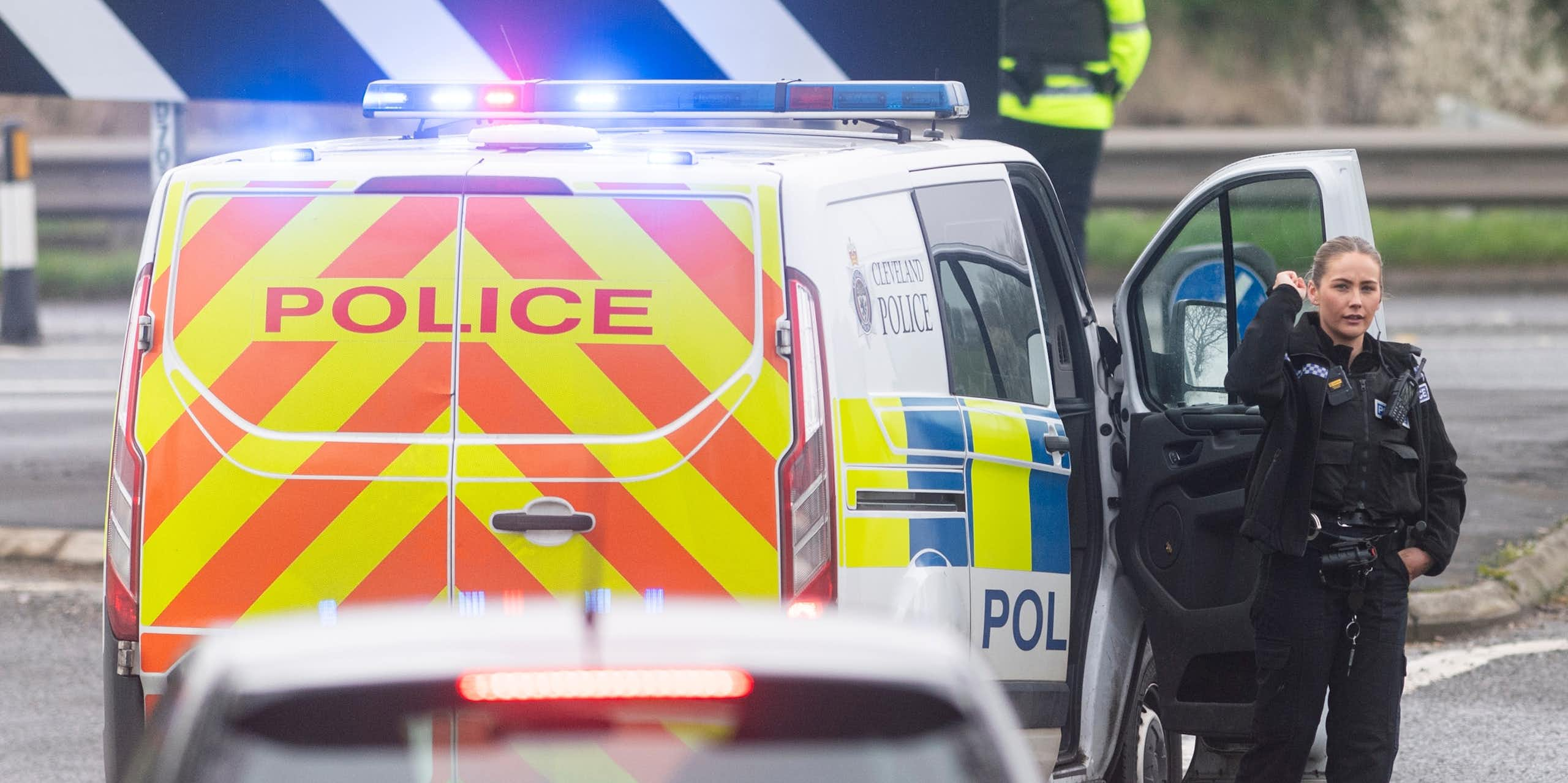 A police officer beside a police van.