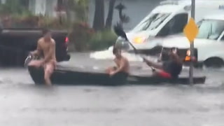 Trio brave Florida floodwaters by riding across intersection in canoe