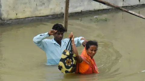 People are shifting their belongings to a safer place following a heavy rainfall in Nagaon District of Assam, India, on July 1, 2024.